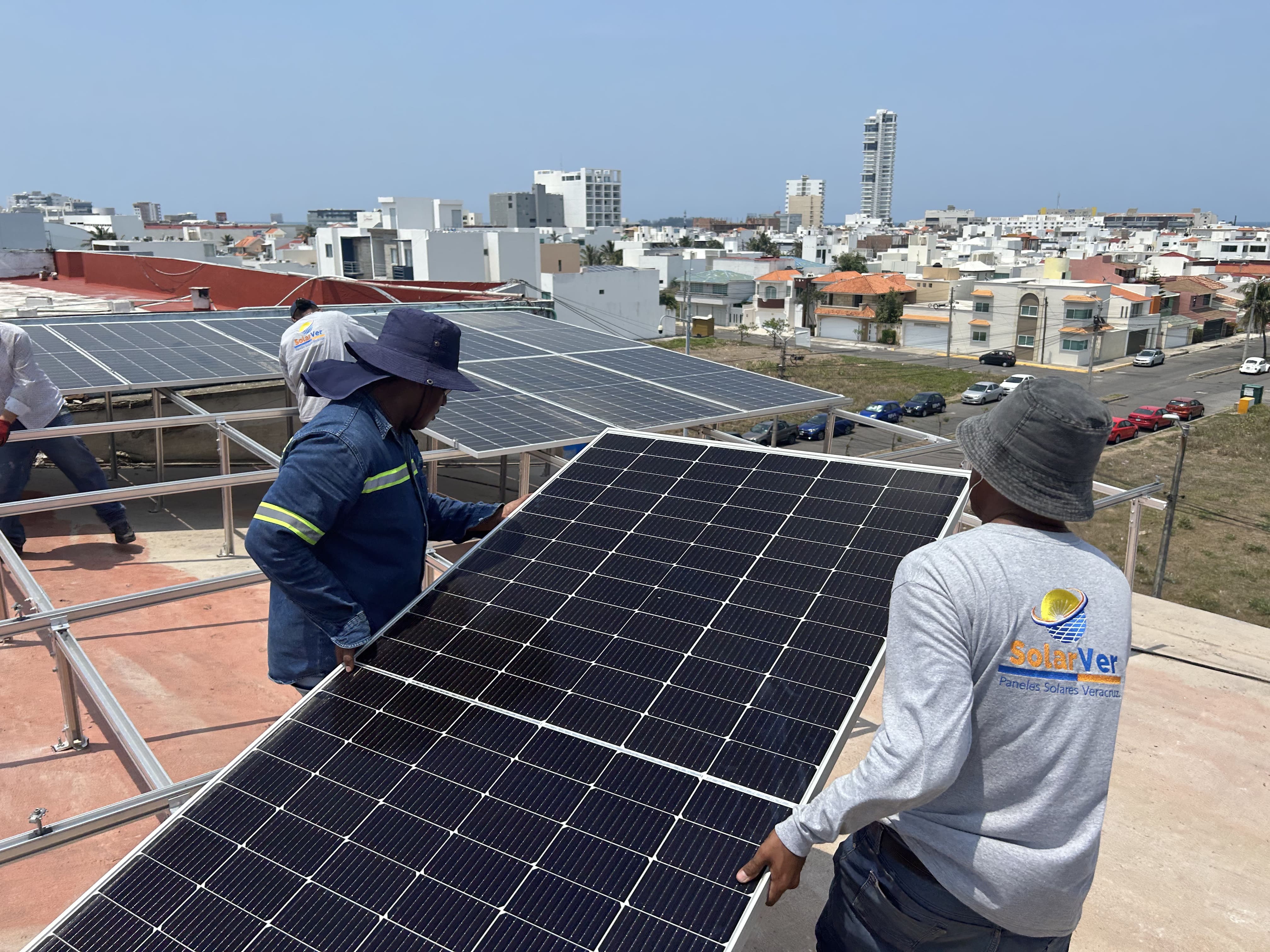 Dos trabajadores transportando paneles solares